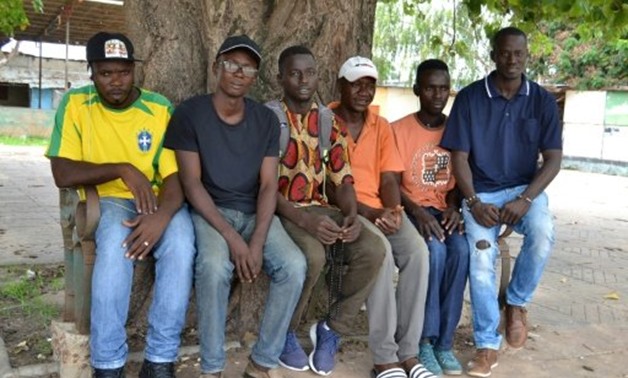 © AFP/File / by Emil Touray | Karamo Keita (in white cap) and fellow migrants have formed a group back home to agitate for job creation from the new government and to dampen expectations among their peers that a life in Europe is within easy reach