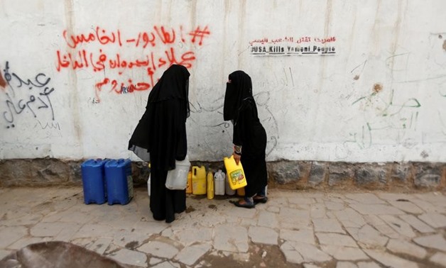 FILE PHOTO: Women carry jerrycans after they filled them up with drinking water from a charity tap, amid a cholera outbreak, in Sanaa, Yemen, July 10, 2017. REUTERS/Khaled Abdullah