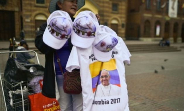 © AFP / by Kelly VELASQUEZ | T-shirts and hats with the image of Pope Francis are on offer in Bogota as Colombia prepares to welcome the pontiff seeking to promote peace after 50 years of civil war
