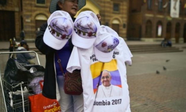 © AFP / by Kelly VELASQUEZ | T-shirts and hats with the image of Pope Francis are on offer in Bogota as Colombia prepares to welcome the pontiff seeking to promote peace after 50 years of civil war
