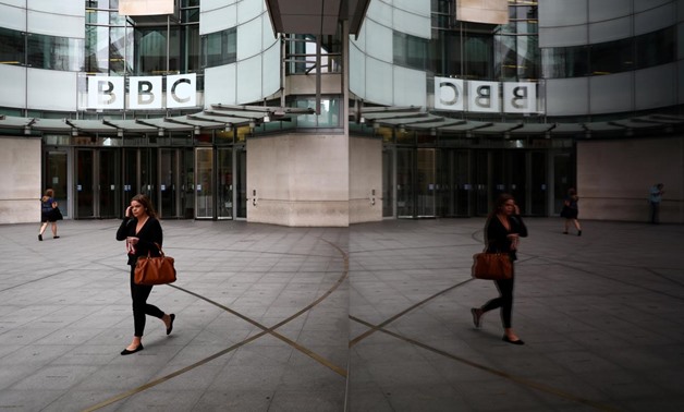 FILE PHOTO: A woman is reflected as she passes the BBC's Broadcasting House in London, Britain July 19, 2017. REUTERS/Neil Hall/File Photo