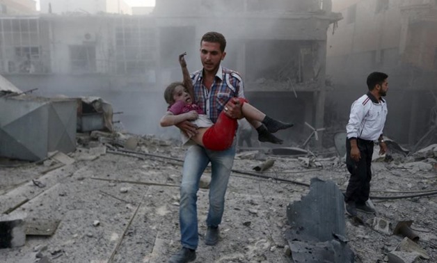 A man holds a girl who survived what activists said was heavy shelling by forces loyal to Syria's president, Bashar al-Assad, in Damascus, Syria, on Tuesday.
