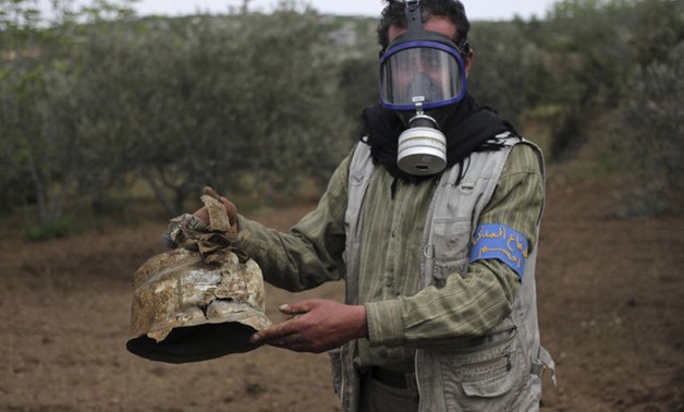A Civil Defence member carries a damaged canister in Ibleen village from what activists said was a chlorine gas attack, on Kansafra, Ibleen and Josef villages, Idlib countryside - REUTERS