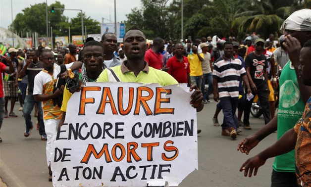 A man holds up a sign during an opposition protest calling for the immediate resignation of President Faure Gnassingbe in Lome - REUTERS
