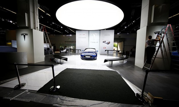 FILE PHOTO: People run preparations at the Tesla company booth during the media day at the Frankfurt Motor Show (IAA) in Frankfurt, Germany, September 14, 2015. REUTERS/Kai Pfaffenbach/File Photo