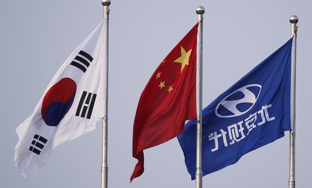 FILE PHOTO: The South Korean and Chinese national flags fly alongside the company flag of Hyundai Motor Co at its plant in Beijing, China, August 30, 2017. REUTERS/Thomas Peter/File Photo