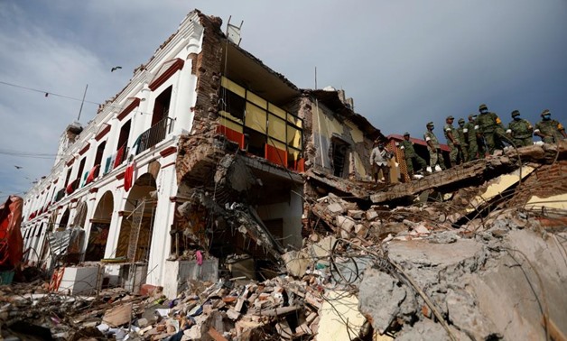 Soldiers remove the debris of a house destroyed in an earthquake that struck off the southern coast of Mexico late on Thursday, in Juchitan, Mexico - Reuters