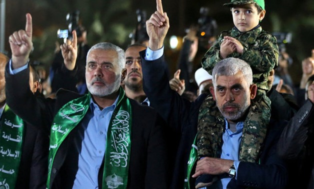 The son of senior Hamas militant Mazen Fuqaha sits on the shoulders of Hamas Gaza Chief Yahya Al-Sinwar as Hamas leader Ismail Haniyeh (L) gestures during a memorial service for Fuqaha, in Gaza City March 27, 2017. REUTERS/Mohammed Salem/File Photo