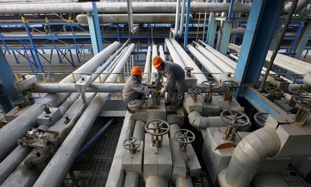 FILE PHOTO: Employees close a valve of a pipe at a PetroChina refinery in Lanzhou, Gansu province January 7, 2011. REUTERS/Stringer/File Photo