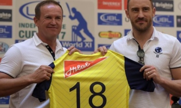 © AFP / by Shahid HASHMI | World XI captain Faf du Plessis (R) and team coach Andy Flower (L) pose with the team shirt during a ceremony in Lahore