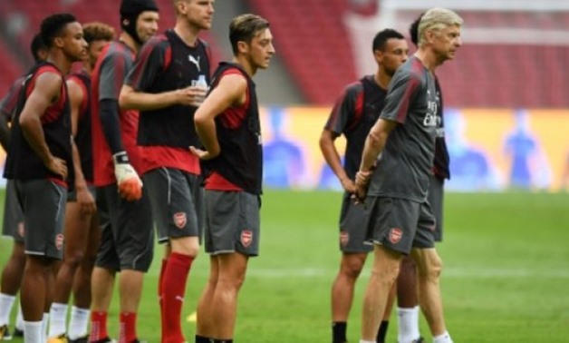 © AFP/File / by John WEAVER | Arsenal manager Arsene Wenger (R) says his team would take the Europa League competition seriously despite the disappointment of missing out on the Champions League after 19 consecutive seasons in Europe's premier competition