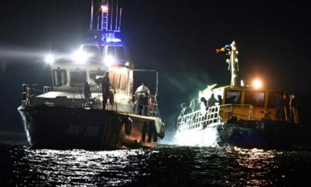 © AFP | A Romanian border police boat (L) pulls a migrant transporting vessel to Midia Port near the Black Sea coastal city of Navodari, on September 13, 2017