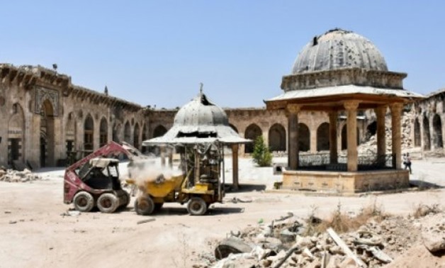 © AFP/File / by Maria Antonova | A digger clears rubble from the courtyard of Aleppo's Umayyad Mosque on July 22, 2017