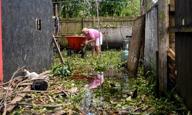 Joan Markel, stands in food waters cleaning debris from her yard, after Hurricane Irma near Jerome, Florida, U.S., September 12, 2017. REUTERS/Bryan Woolston