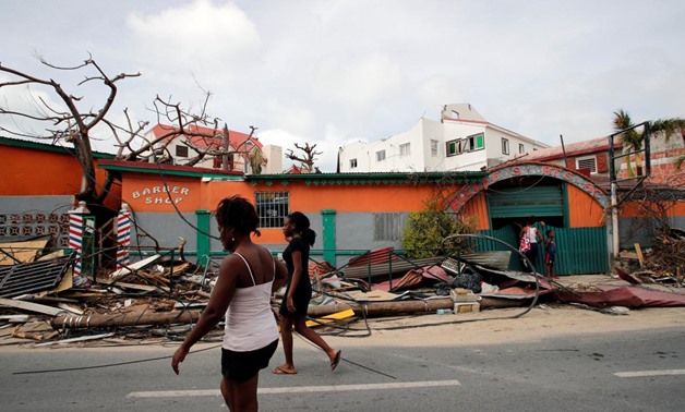 Residents walk in front of houses destroyed by Hurricane Irma during the visit of France's President Emmanuel Macron in the French Caribbean islands of St. Martin September 12, 2017. REUTERS/Christophe Ena/Pool