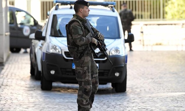 An armed French soldier stands near the site where a car slammed into soldiers on patrol in Levallois-Perret, outside Paris.(AFP File Photo)
