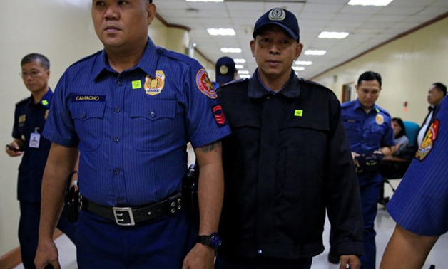 Philippines National Police (PNP) officer Arnel Oares is escorted as he appears during a hearing on the killing of 17-year-old high school student Kian Delos Santos in a recent police raid, at the Senate headquarters in Pasay city, metro Manila, Philippin