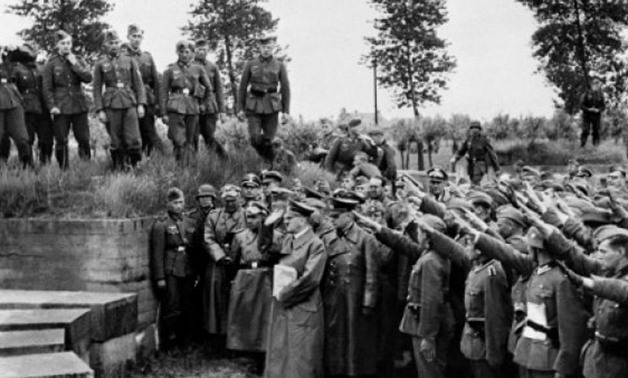 © FRANCE PRESSE VOIR/File | Adolf Hitler pays tribute to German soldiers fallen during World War I, during a 1940 visit to the Langemark cemetery in Belgium