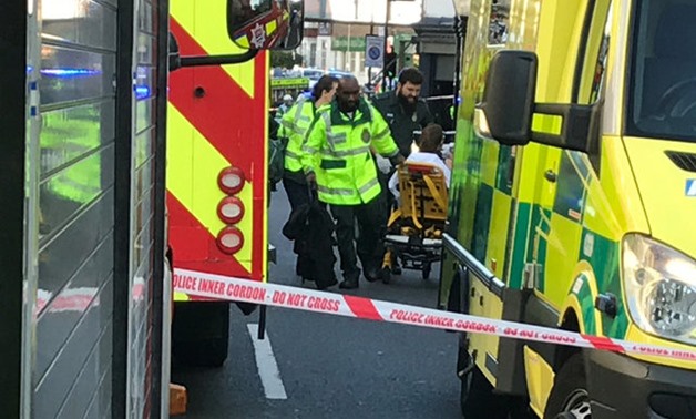 Emergency personnel attend to a person after an incident at Parsons Green underground station in London - REUTRERS