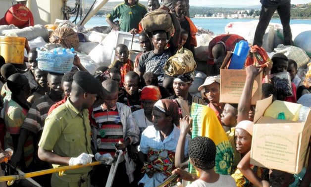 Tanzanian police control Burundi refugees as they arrive at the Kigoma port in western Tanzania - Reuters