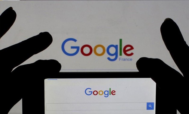 A woman holds her smart phone which displays the Google home page - file photo, Reuters/Eric Gaillard/Illustration