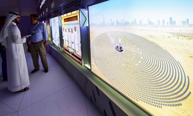 Visitors look at screens displaying images of the Mohammed bin Rashid Al-Maktoum Solar Park on March 20, 2017, at the solar plant in Dubai