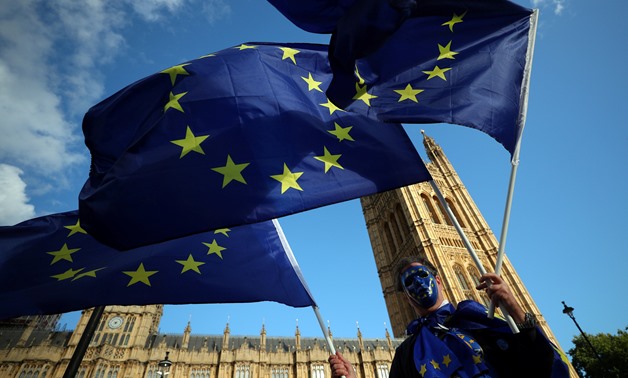 A demonstrator waves European Union flags outside the Houses of Parliament in London, Britain, September 13, 2017. REUTERS/Hannah McKay