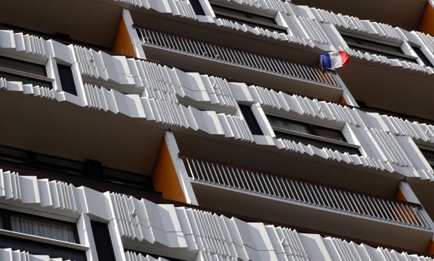 A French flag flies from the balcony of an apartment block in Paris. REUTERS-Mal Langsdon