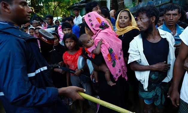 A Bangladeshi policeman controls the crowd of Rohingya refugees waiting for aid in Cox's Bazar, Bangladesh, September 17, 2017. REUTERS/Danish Siddiqui
