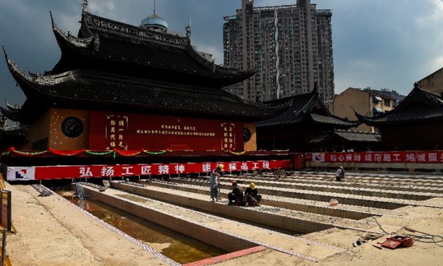 Workers initially pumped cement into the foundations of the Jade Buddha Temple's hall in Shanghai to strengthen them, before embarking on the big move (AFP Photo/CHANDAN KHANNA)