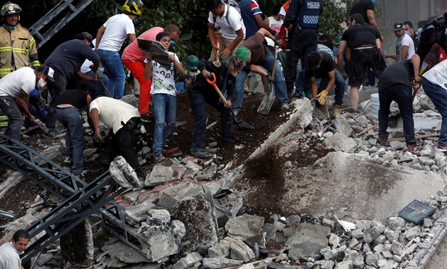 People remove debris of a collapsed building after an earthquake hit Mexico City, Mexico September 19, 2017. Picture taken September 19, 2017 - REUTERS
