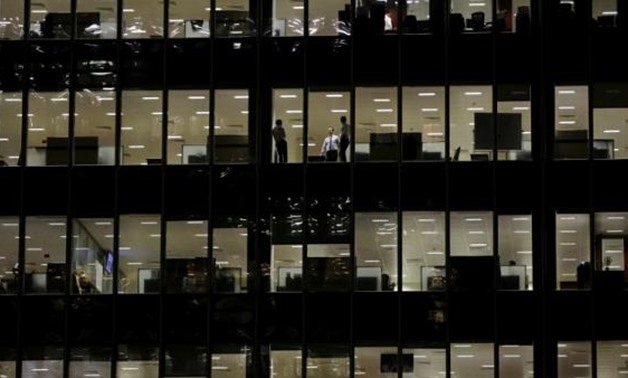 FILE PHOTO: Workers are seen in office windows in the financial district of Canary Wharf in London, Britain, November 3, 2015. REUTERS/Kevin Coombs/File Photo