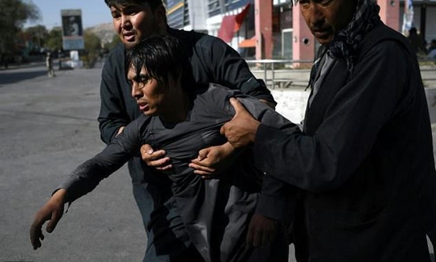 Shiites carry a wounded friend after a suicide attack on a mosque in Kabul on August 25, 2017-AFP