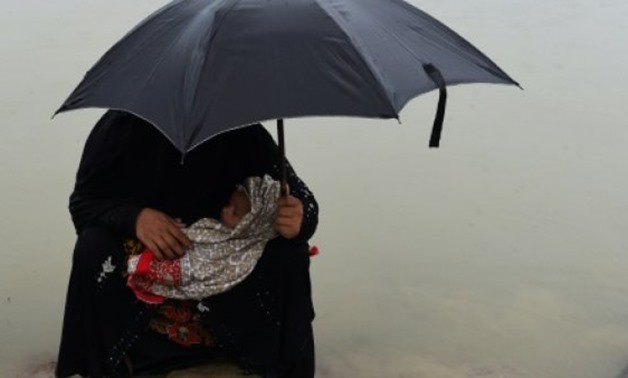 © AFP/File | Rohingya refugee woman waits for aid with her child in Teknaf in Bangladesh