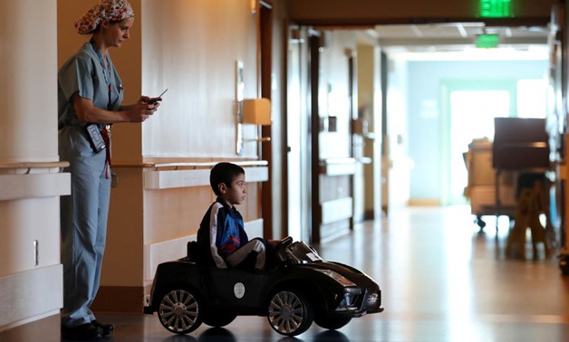 Doctor Daniela Carvalho controls Jonathan Jauregui, 7, remotely as Rady Children's Hospital unveil a program that uses remote control cars, donated by the local police officers charity, to take young patients to the operating room, in San Diego, Californi