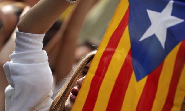 A protester holds up an Estelada (Catalan separatist flag) as a crowd gather outside the High Court of Justice of Catalonia in Barcelona, Spain, September 21, 2017. REUTERS/Susana Vera