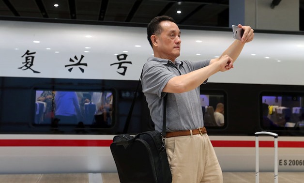 A passenger takes a selfie with a Fuxing bullet train before it departs from Beijing South Railway Station to Shanghai — Reuters