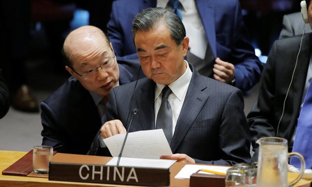 Chinese Foreign Minister Wang Yi listens to China's Ambassador to the United Nations Liu Jieyi as he attends a meeting of the Security Council to discuss peacekeeping operations during the 72nd United Nations General Assembly at U.N. headquarters in New Y