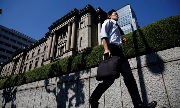 FILE PHOTO: A man runs past the Bank of Japan (BOJ) building in Tokyo, Japan, July 29, 2016. REUTERS/Kim Kyung-Hoon/File Photo