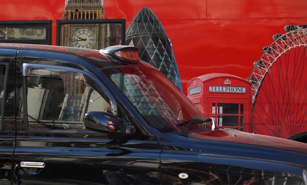 A London cab passes a hoarding with images of some of the city's landmarks, in central London- Reuters