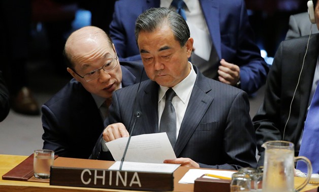 Chinese Foreign Minister Wang Yi listens to China's Ambassador to the United Nations Liu Jieyi as he attends a meeting of the Security Council to discuss peacekeeping operations during the 72nd United Nations General Assembly at U.N. headquarters - REUTER