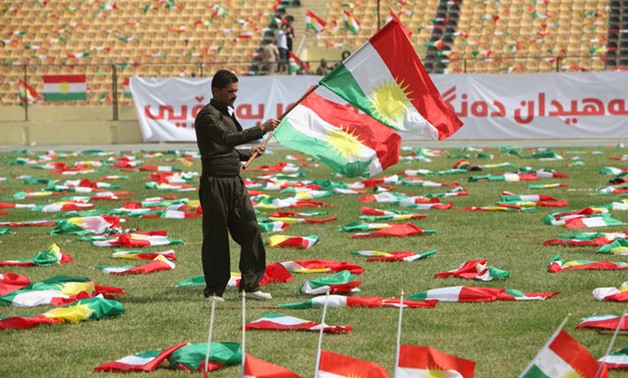 A man carries the Kurdistan flags before the start of a rally calling to vote yes in the coming referendum, in Erbil, Iraq September 22, 2017. REUTERS/Azad Lashkari
