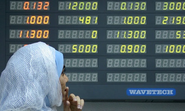 FILE PHOTO: A Bahraini woman checks the stocks at the Bahrain Stock Exchange in the capital Manama July 21, 2005. REUTERS/Hamad I Mohammed/File photo