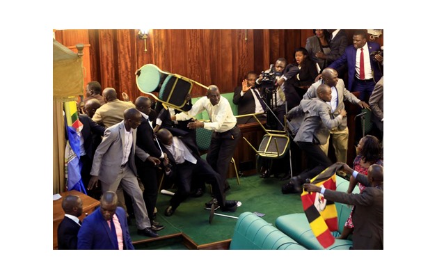 Ugandan opposition lawmakers fight with plain-clothes security personnel in the parliament while protesting a proposed age limit amendment bill debate to change the constitution for the extension of the president's rule, in Kampala, Uganda September 27, 2