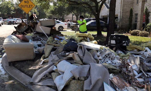 The contents of a flooded home are moved to the street in the aftermath of tropical storm Harvey in Katy, Texas - REUTERS