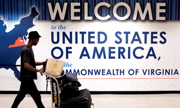 A man exits the transit area after clearing immigration and customs on arrival at Dulles International Airport in Dulles - REUTERS