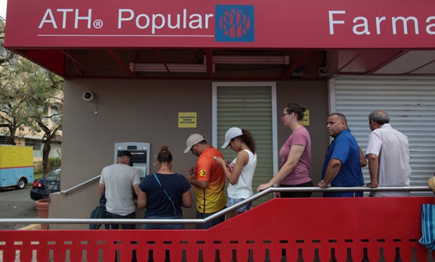 People queue to get money from an ATM after the island was hit by Hurricane Maria, in San Juan - REUTERS