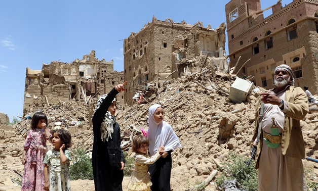 People stand past houses destroyed in an outskirt of the northwestern city of Saada, Yemen September 5, 2017. REUTERS/Naif Rahma