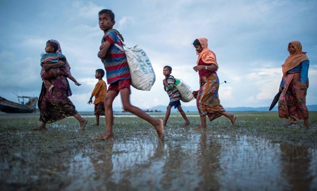 Rohingya Muslim refugee walks after crossing the border from Myanmar, on the Bangladeshi shores of the Naf river in Teknaf on September 29, 2017./AFP