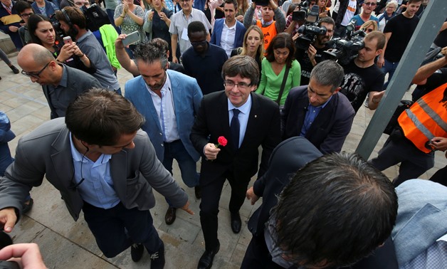 Catalan President Carles Puigdemont holds a carnation while visiting the polling station where he was expected   - REUTERS/Albert Gea